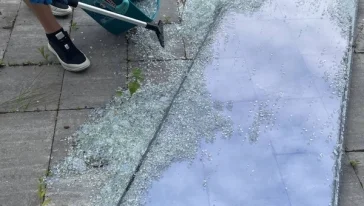 Мастер демонстрирует снятый старый стеклопакет перед заменой.