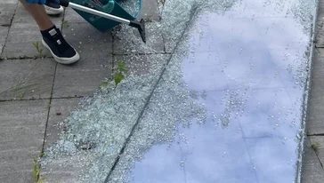 Мастер демонстрирует снятый старый стеклопакет перед заменой.