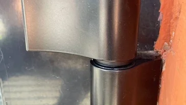 Процесс замены дверных петель на алюминиевой конструкции.