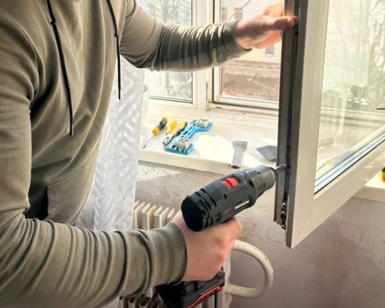 мастер меняет оконную фурнитуру