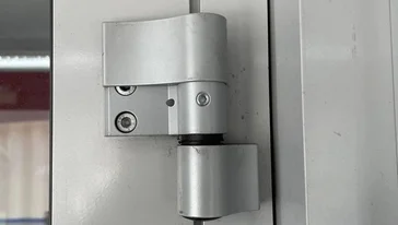 Специалист регулирует петли после замены.