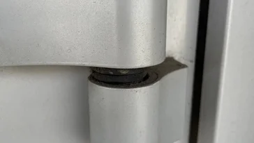 Снятие старой петли с алюминиевой дверной коробки.