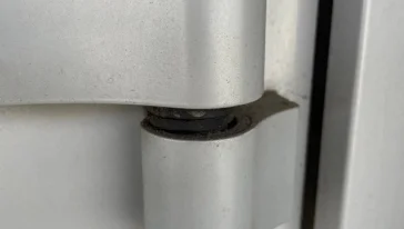 Снятие старой петли с алюминиевой дверной коробки.